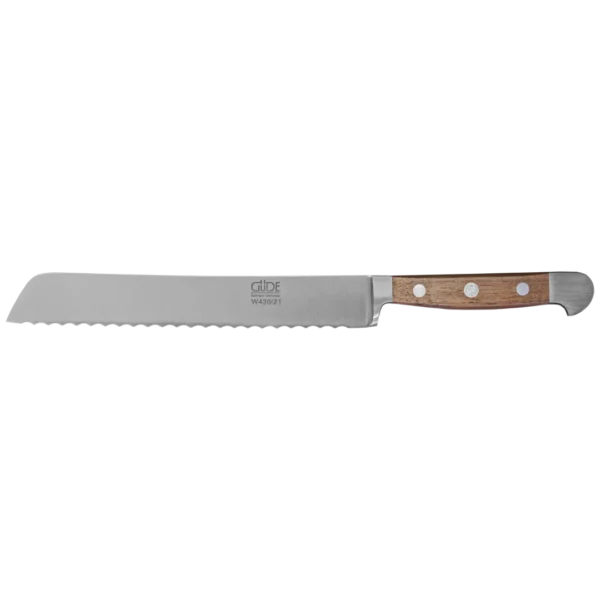 Ein Bild aus dem Taiga Store von taiga.green. Ein Brotmesser mit Wellenschliff, Holzgriff und drei Nieten. Die lange, silberne Klinge ist mit dem Markennamen Güde graviert. Das Messer ist waagerecht auf einem schlichten Hintergrund angeordnet. Jetzt bestellen im Eco Shop von www.taiga.green. Hier nachhaltig einkaufen mit dem Taiga Eco Rating